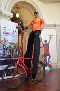 A man on stilts riding a bike at the Cheltenham Festival of Cycling launch
